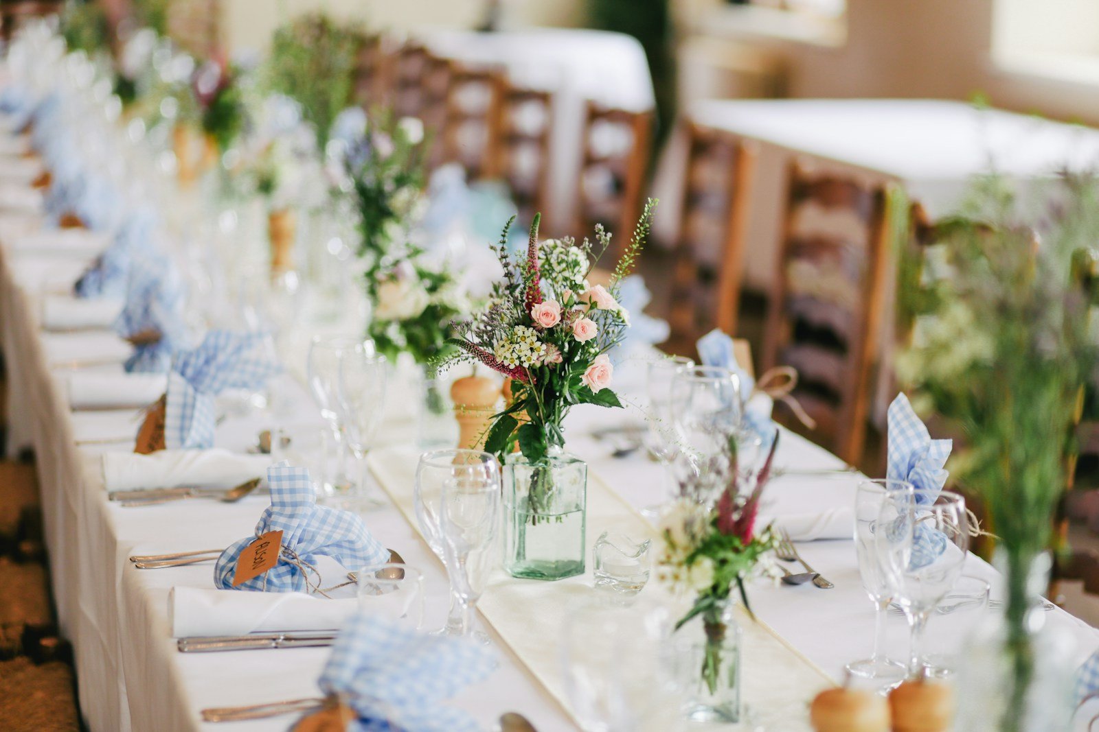 An elegant outdoor celebration with flowers, dining tables and a garden setting